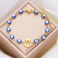 Golden Evil Eye bracelet with blue beads and a round charm featuring the letter W - Letter W