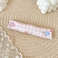 Pink and white checkered fabric cable organizer with heart-shaped snaps on a lace background - Pink Gingham Bow