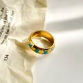 Macro shot of gold-plated wide ring featuring light blue enamel star patterns - Blue Pentagram