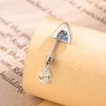 Silver belly button ring with blue stones and teardrop crystal on beige background - Blue + Blue (Left)