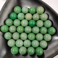 Macro shot of polished green aventurine crystal spheres on a black display tray - 25mm No Hole Sphere / Green Aventurine