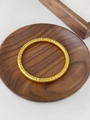 Dettaglio del bracciale dorato in acciaio inossidabile con motivo geometrico a rombi - Oro Trama Incrociata