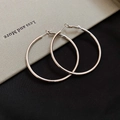 Minimalist silver geometric hoop earrings placed on a notebook and black fabric background - 925 Silver Needle / Silver - Large (5cm)