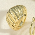 Dettaglio macro di un anello dorato spesso con texture vintage a spirale a croissant - Anello a onda croissant