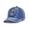 Blue denim baseball cap with crystal rhinestones and metal studs in a 45-degree side view - Greek Symbol ZΦB Rhinestone (Dark Blue)