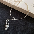 Détail du collier en Y avec perles blanches, perles argentées et pendentifs - Collier de Perles en Forme de Y Argent et Blanc