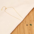 Dettaglio della collana dorata con pietra verde smeraldo ovale e pendente nero rettangolare - Stile Doppio Pendente Catena d'oro con Smeraldo Ovale e Pietra Nera (5#)