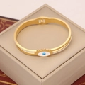 Detail eines goldenen Armreifs mit blauem Auge und weißen Strasssteinen auf Schmuckbox - Böser Blick Strass-Stil (5#)