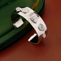 Detail van zilveren manchetarmband met vijf witte stenen op groene fluwelen doos - Zilver