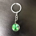Silver keychain featuring a glass orb pendant with a real green four-leaf clover inside - Four Leaf Clover