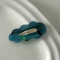 Close-up of cloud-shaped acetate hair clip with teal marbling and gold metal detail - Blue
