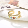 Macro view of double-layered gold ring with colorful evil eye charms and clear rhinestones - Multicolored Eyes Style