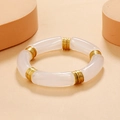 Detail of white resin tube bracelet with golden metal rings on warm beige background - Solid White / Gold