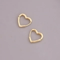 Detailed view of heart-shaped gold hoop earrings with a polished metallic finish - Medium Heart / Gold