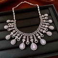 Détail du collier argenté avec pendentif en cristal rose sur présentoir en cuir noir - Collier - Argent - Rose