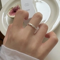 Nahaufnahme eines minimalistischen Silberrings mit Zirkonia an einer Hand in sanftem Licht - Einstellbar Offen / Stapelbarer Stil mit Einzelstein und Mikropavé-Band(J3348)