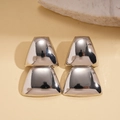 Minimalistische geometrische Trapez-Ohrringe mit Hochglanz-Finish auf beigem Hintergrund - Silber (Silberstift) / Silber