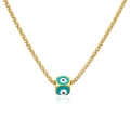 Golden double chain necklace with evil eye enamel cube pendant on white surface - Green