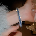 Close-up of sparkling blue and silver diamond bracelet on wrist with elegant fur detail - Blue Rhinestone