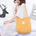 Bright yellow corduroy tote bag with dual shoulder straps shown in a bright lifestyle setting - Ginger Yellow