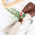Detail of pine needle napkin ring with red berries and pine cone on a velvet napkin - Pine Needle and Pinecone Napkin Ring