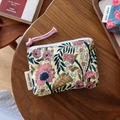 Detail of vintage cotton coin purse with floral pattern and zipper on wooden table - White Pink Floral