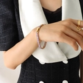 Golden bracelet with purple zircon inlay and matching rings on female model hand - 19cm Bracelet Extension / Purple