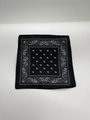 Vista macro piatta di una bandana nera con motivi paisley bianchi sul tessuto - Laccio sottogola bianco / Fazzoletto quadrato nero 16 cm