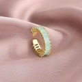 Adjustable gold ring featuring rectangular light green zircons on a purple silk backdrop - Cyan