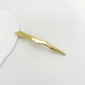 Detailansicht der unregelmäßigen welligen Haarklammer aus Goldlegierung auf Weiß - Gold Hügel-Stil