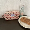 Macro shot of a floral corduroy makeup bag on a wooden table for travel storage - Beige Red Floral Tulip