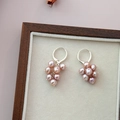 Detail shot of pink freshwater pearl grape cluster earrings in a wooden jewelry box - Natural Purple