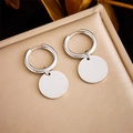 Close-up of silver hoop earrings with polished disc pendants on golden textured pad - Glossy Disc Hoop Style (E5794 Steel Color)