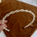 Close-up of elegant double-layered pearl headband with golden metallic twist detail - Twisted Pearl