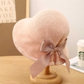 Detail of peach pink woven sun hat featuring a wide matching bow ribbon on a wood stand - M (56-58cm) / Pink