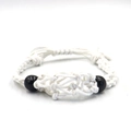 Macro shot of white handmade woven cord bracelet with black bead accents and adjustable knot - Bracelet / White