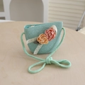 Detail of mint green straw bag with ribbon flowers on light wood background - Bag-Lake Blue