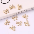Detailed view of nine gold-plated bow-shaped charms with sparkling cubic zirconia inlay - Bowknot 10*13mm