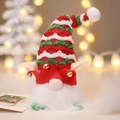Weihnachtswichtel mit rot gewelltem Hut, Glocken und warmem Bokeh-Hintergrund - Zwerg mit rotem Hut und Licht