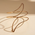 Detailed view of polished golden irregular leaf spiral arm cuff on a minimalist background - Irregular Spiral Wave Arm Cuff / Gold