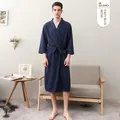 Navy blue men's waffle knit bathrobe with belted waist and front pockets in a home setting - Navy Blue (Men)