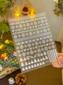 Macro shot of white snowflake and reindeer nail art decals on a model hand with festive decor - Embossed YT3737 (Pure White Xmas)