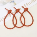 Close-up of three matte orange silicone cable ties with adjustable gear structure - Dark Coffee