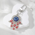 Macro view of silver Hamsa Hand keychain with blue evil eye charms and rhinestones - Silver Red Eye Style