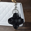 Portachiavi con fiore di camelia in pelle nera su una borsa a mano trapuntata - Nero