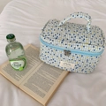 Detail of blue and yellow checkered quilted makeup bag with handle on white bedding - Blue Polka Dot