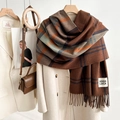 Classic thick plaid scarf with tassels and Good Luck patch on a white winter coat - Coffee