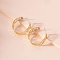 Close-up of golden C-shaped hoop earrings with intricate geometric cutout patterns - C-Shaped Hollow Geometric