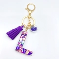 Letter L keychain with purple tassel and resin glitter filling in gold plating - L