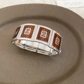 Detailansicht eines breiten elastischen Armbands mit brauner Emaille und silbernen Spiralen - Breite Spirale Emaille / Silber Bernsteinbraun